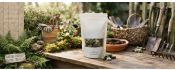 WildKind compostable pet treat pouch on a garden potting bench